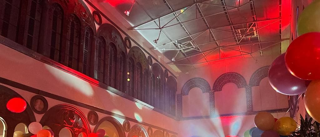 Umsetzung: Saal mit roten Bögen, Lichteffekten und Ballons unter dem Glasdach