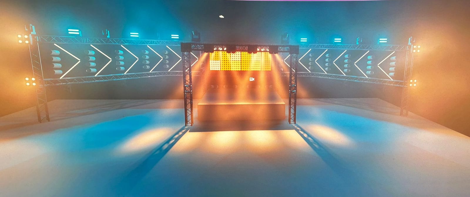 Konzept: Traversenflügel mit Pfeil-Design, LED-Wand und Lichtstimmung in Amber und Türkis